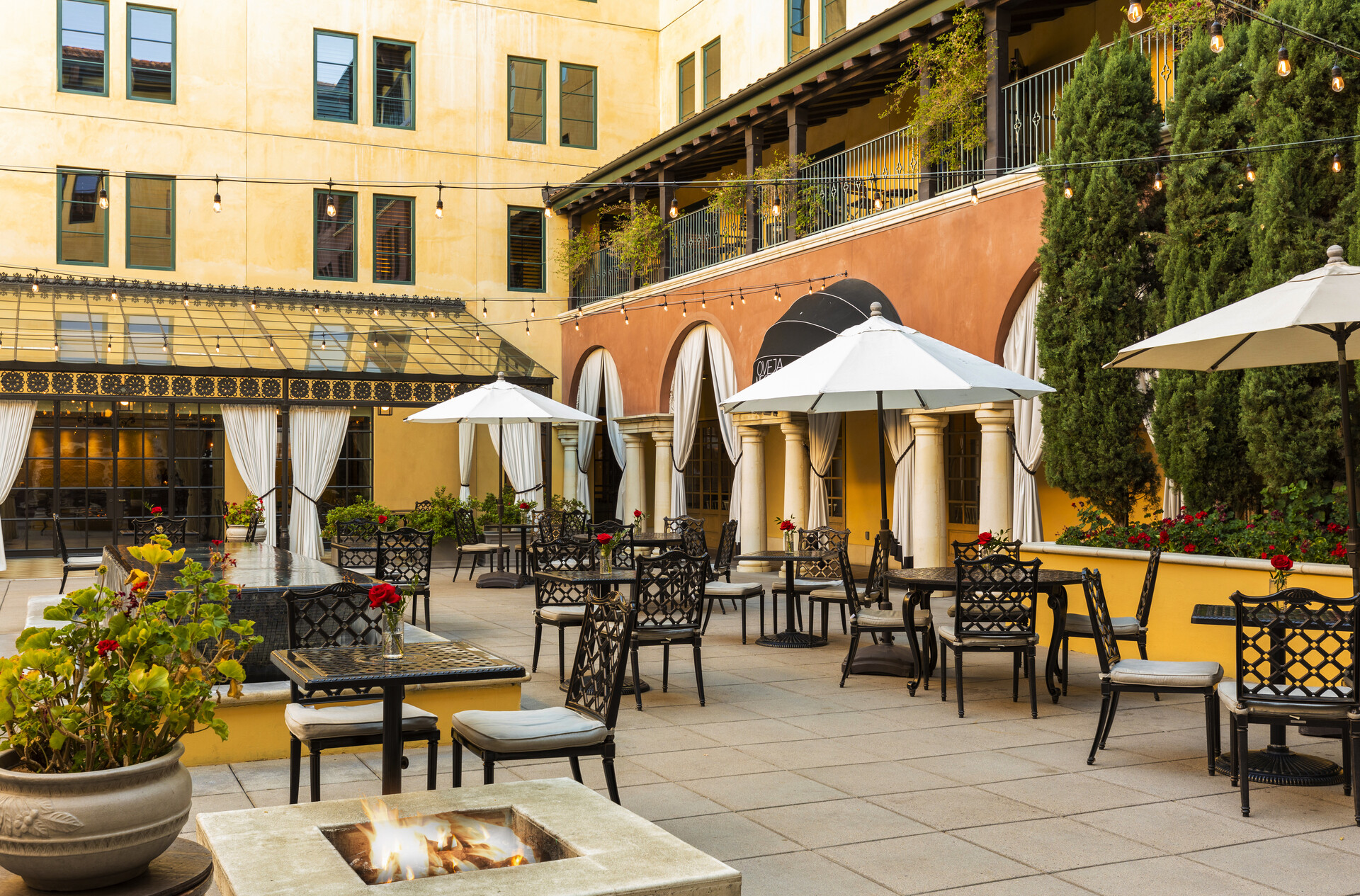 Hotel Valencia courtyard with palms, tables and the cream hotel façade