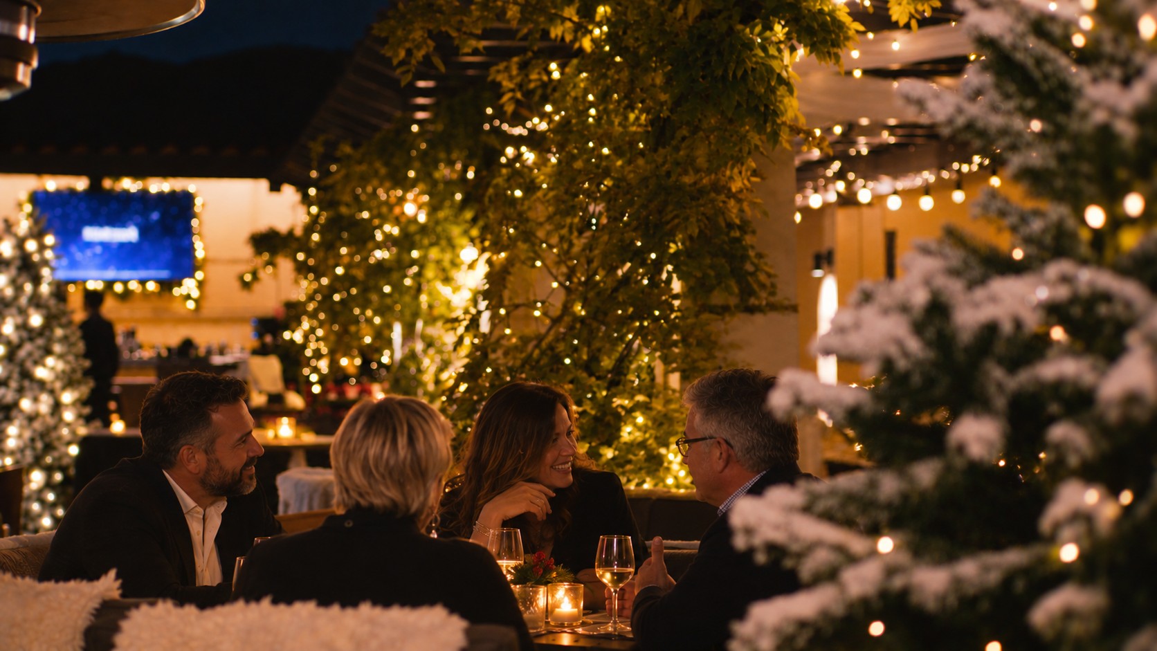 Guests dining among frosted trees and string lights at Cielo Rooftop
